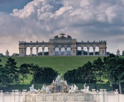 An elegant, neoclassical structure with grand arches, columns, and a soaring rooftop, perched on a hill.