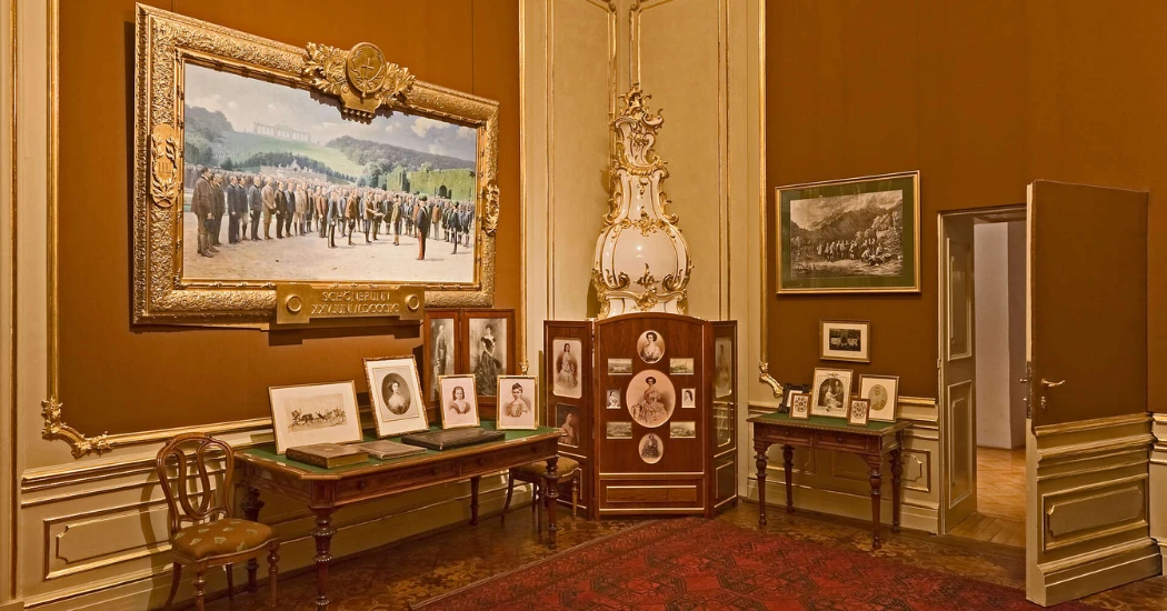 Decorative palace room with framed images and royal artifacts from Schönbrunn’s past 