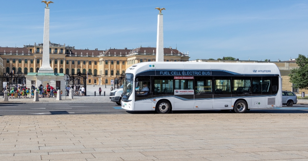 A bus stops in front of the Schonbrunn Palace main entrance gate.
